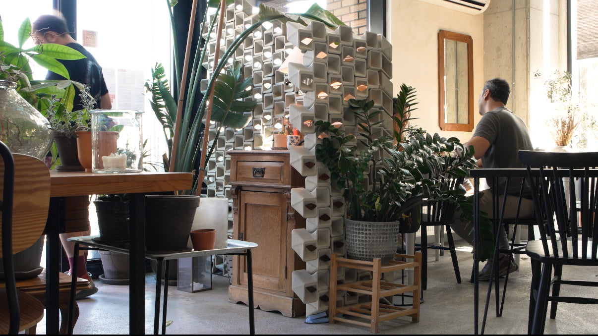Videoyu yükle: I designed this wall for Mozz, one of the best pizza restaurants in Europe. From the very beginning, the idea was that it should feel like it truly belongs to the space.The design inputs were clear: it had to let light pass through, block the wind, and stay modular so it could be reconfigured.I worked for months, testing countless joints. Clay is unpredictable, and tolerances shift with distortion during drying and firing. Through many prototypes and endless adjustments, I learned how to control the distortion with customized print paths.Along the way I had two big realizations:First, the wall shouldn’t just exist as a surface. It needed depth, so light could enter and shadows could fall not only on the surface but also inside the wall, making it feel like it truly belongs to the space.Second, the joints weren’t something to hide inside the bricks. They had to become the main driver of the design.That’s how the final bricks took shape. They allow indirect light to pass through while blocking the wind, and they interlock in 3D.173 interlocking bricks, 3D printed in stoneware, laguna granite clay and fired at 1280°C.